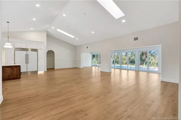 an empty room with wooden floor and window
