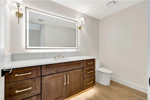 a bathroom with a granite countertop sink a toilet and shower