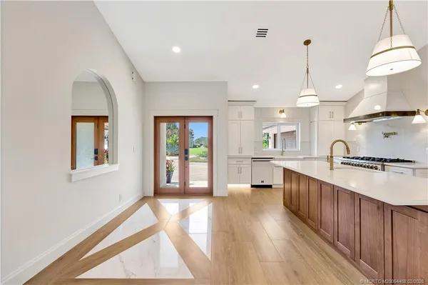a kitchen with stainless steel appliances granite countertop a sink a stove and a refrigerator
