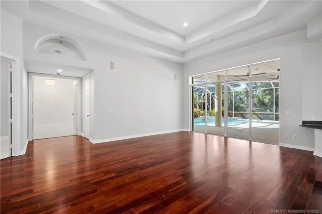 a kitchen with stainless steel appliances granite countertop a refrigerator a sink dishwasher a stove and white cabinets with wooden floor