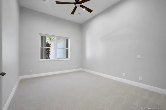 a view of empty room with wooden floor and a ceiling fan