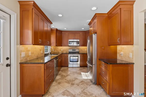 a kitchen with stainless steel appliances granite countertop a refrigerator and a stove