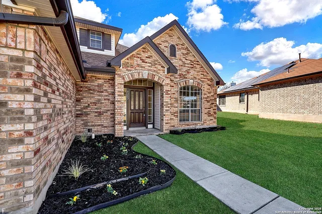 an empty room with windows fireplace and a ceiling fan