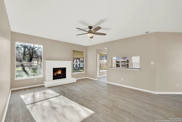 a view of an empty room with window and fireplace
