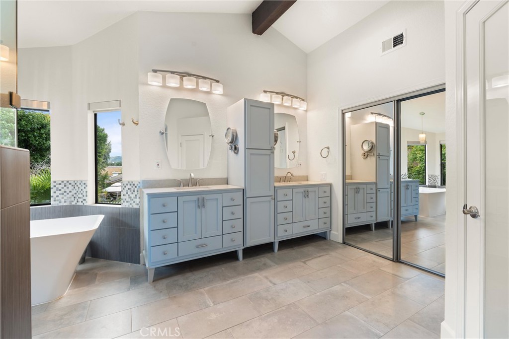 24692 Kings Road Laguna Niguel, CA 92677 - Photo 19 of 39 a spacious bathroom with a double vanity sink a mirror a bathtub and a shower