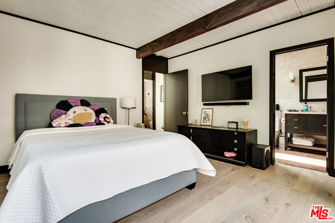 9624 Yoakum Drive Beverly Hills, CA 90210 - Photo 14 of 27 a bedroom with a bed and a flat tv screen on wall