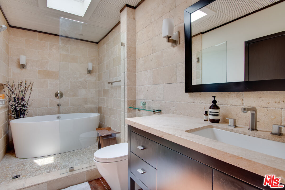 9624 Yoakum Drive Beverly Hills, CA 90210 - Photo 15 of 27 a bathroom with a tub a sink and mirror