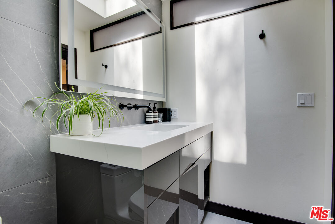 9624 Yoakum Drive Beverly Hills, CA 90210 - Photo 19 of 27 a bathroom with a sink and a mirror