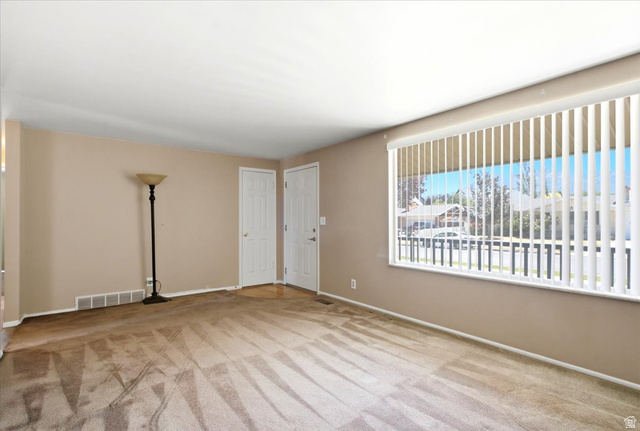 7050 South 260 East Midvale, UT 84047 - Photo 13 of 28 Spacious room featuring neutral-toned walls, carpeted flooring, and a large window with vertical blinds
