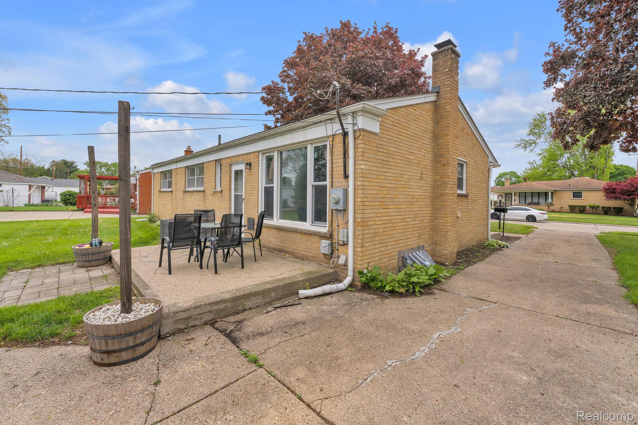 37022 Pinewood Road Wayne, MI 48184 - Photo 27 of 30 Back of house featuring brick siding, a chimney, a patio area, and outdoor dining area
