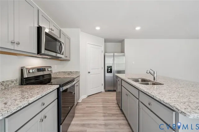 a kitchen with stainless steel appliances granite countertop a sink stove microwave and refrigerator