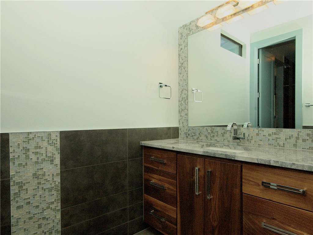 306 Franklin Boulevard, Unit A Austin, TX 78751 - Photo 14 of 19 a bathroom with a granite countertop sink and a mirror