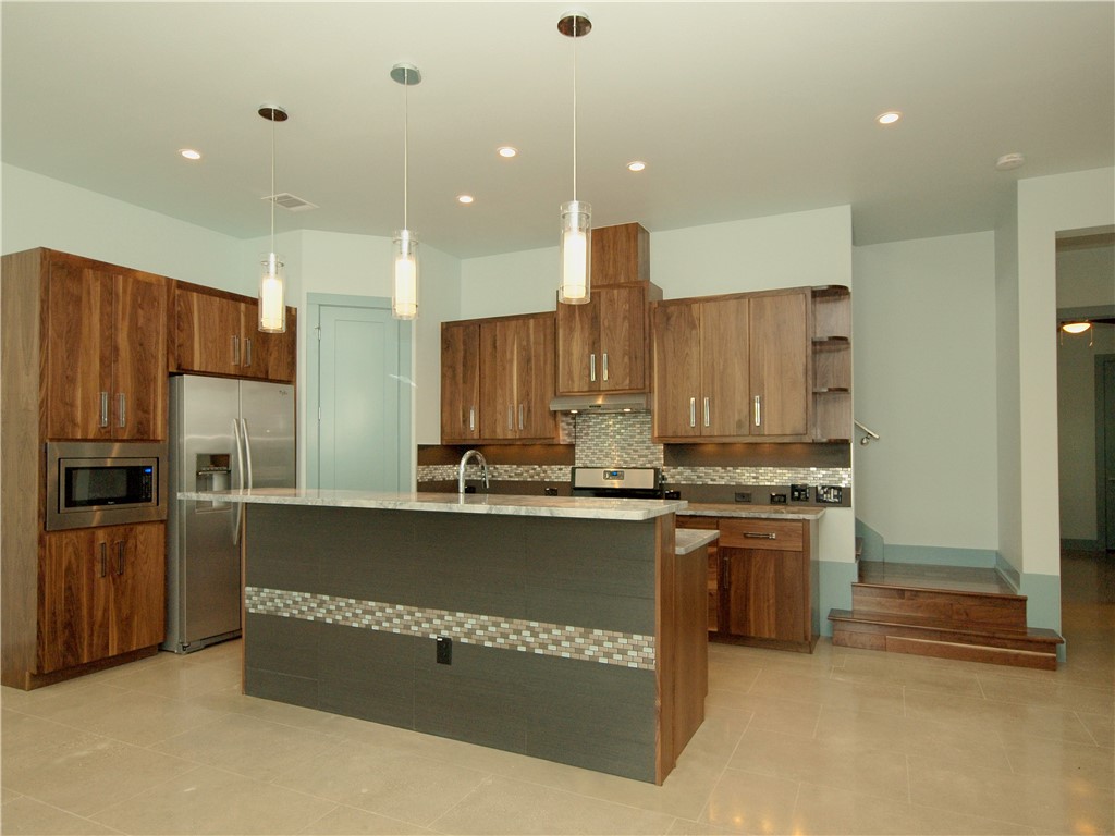 306 Franklin Boulevard, Unit A Austin, TX 78751 - Photo 7 of 19 a kitchen with stainless steel appliances granite countertop a refrigerator a stove and a sink