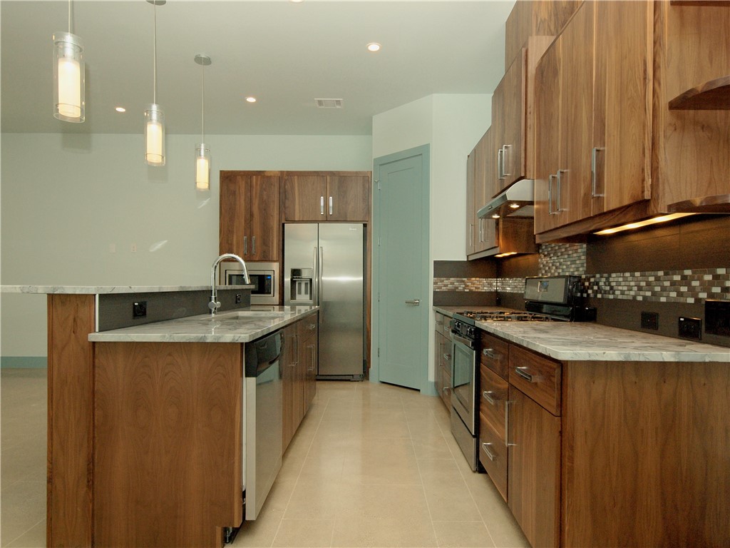 306 Franklin Boulevard, Unit A Austin, TX 78751 - Photo 8 of 19 a kitchen with stainless steel appliances granite countertop a sink a stove and a refrigerator