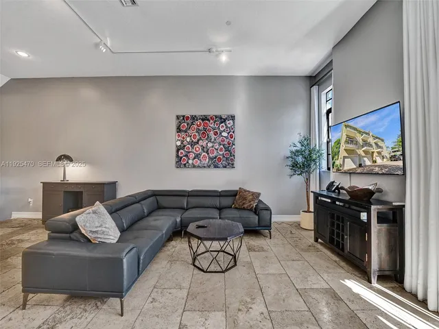 a view of a refrigerator in kitchen and an empty room