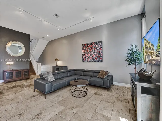 a balcony of a house with wooden floor outdoor seating and yard in the back