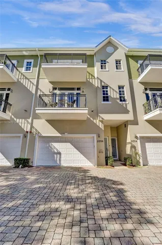 a view of a house with a yard and potted plants