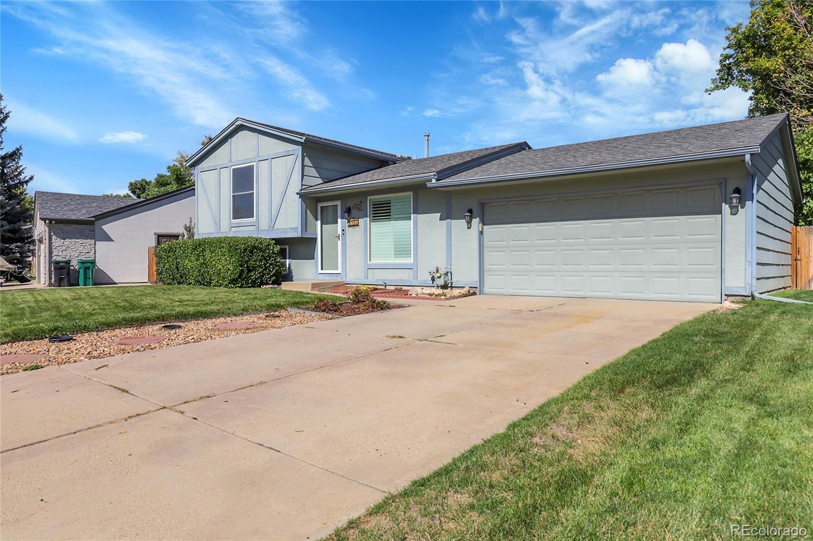 9324 Field Lane Broomfield, CO 80021 - Photo 4 of 43 a front view of a house with a yard and garage