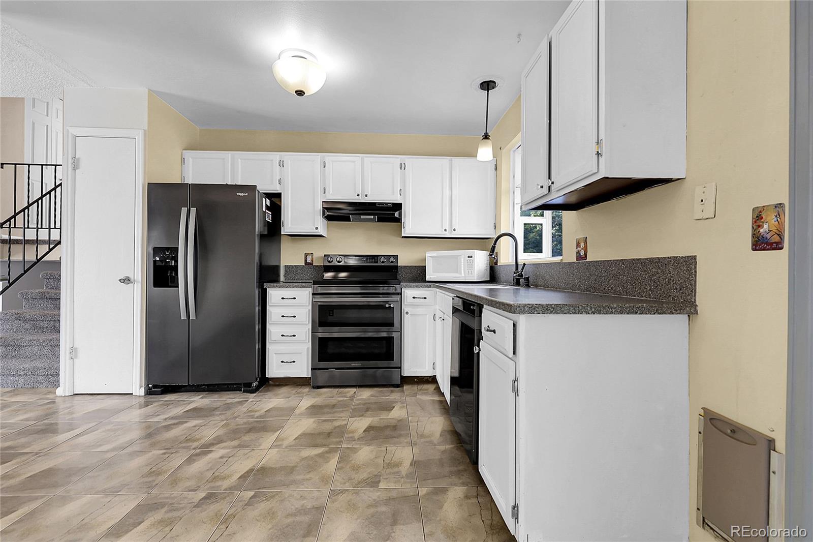9324 Field Lane Broomfield, CO 80021 - Photo 9 of 43 a kitchen with stainless steel appliances granite countertop a refrigerator stove and sink