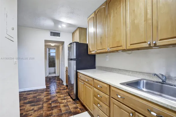 a kitchen with stainless steel appliances granite countertop a refrigerator and a sink