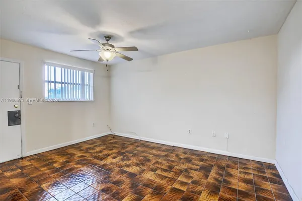 a view of a room with wooden floor and a chandelier fan