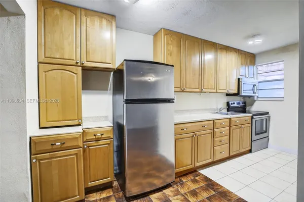 a kitchen with stainless steel appliances granite countertop a refrigerator a stove and a sink with granite countertops