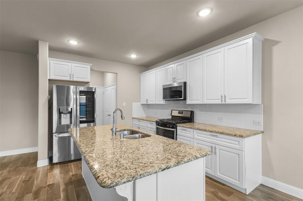2900 Country Church Road McKinney, TX 75071 - Photo 8 of 40 a kitchen with stainless steel appliances granite countertop a sink stove and refrigerator