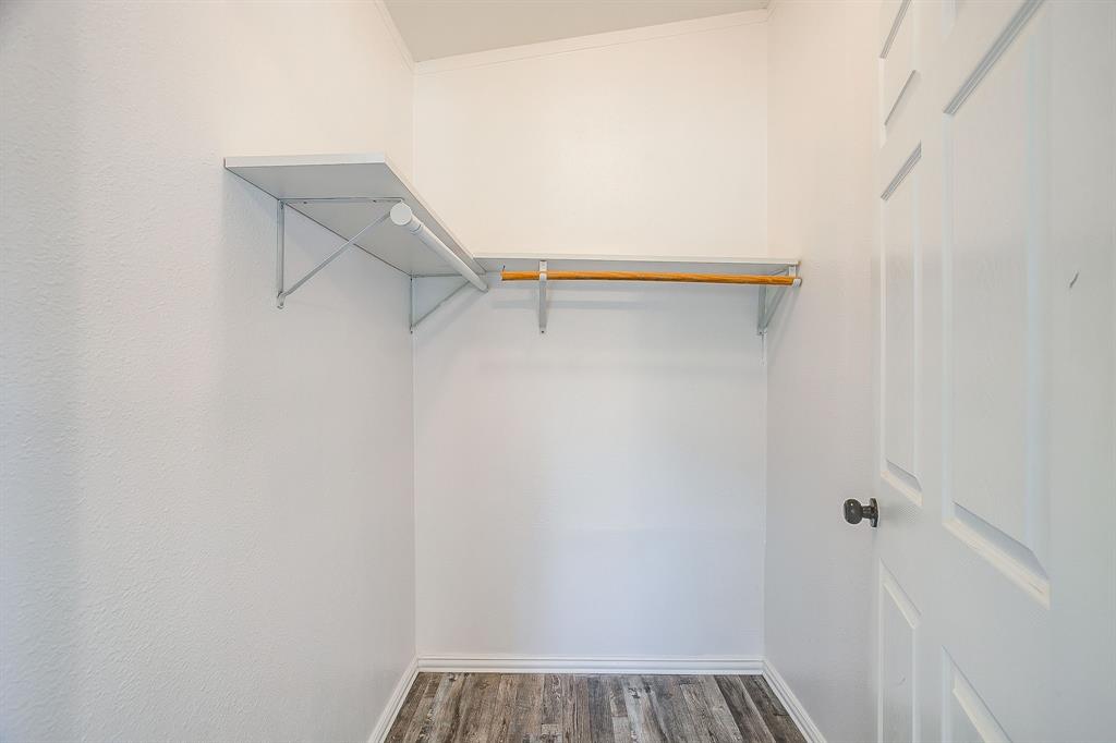 178 Valley Lake Lane Springtown, TX 76082 - Photo 20 of 33 Recessed storage area featuring wood-finish flooring, white walls, and a multi-panel door with a dark knob