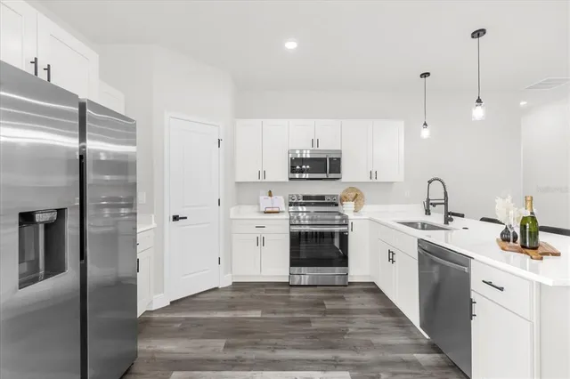 a kitchen with stainless steel appliances and white cabinets