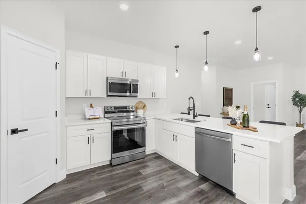 a kitchen with stainless steel appliances kitchen island a sink a stove and cabinets