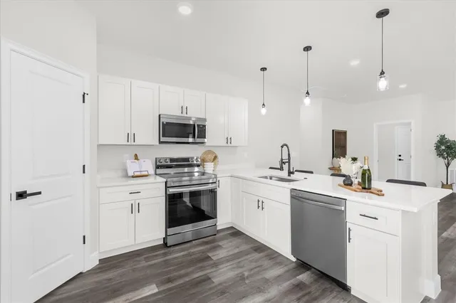 a kitchen with stainless steel appliances kitchen island a sink a stove and cabinets