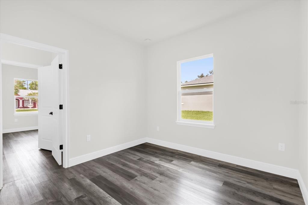 4535 Southwest 172nd Street Road Ocala, FL 34473 - Photo 19 of 35 an empty room with wooden floor and windows