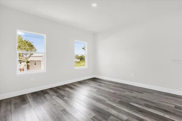 an empty room with wooden floor and window