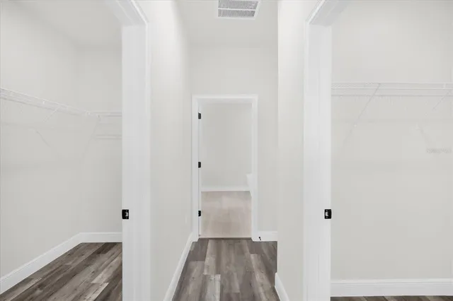 a view of a hallway with wooden floor and closet