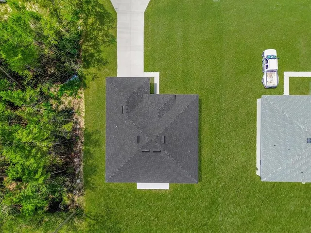 an aerial view of a house with a yard