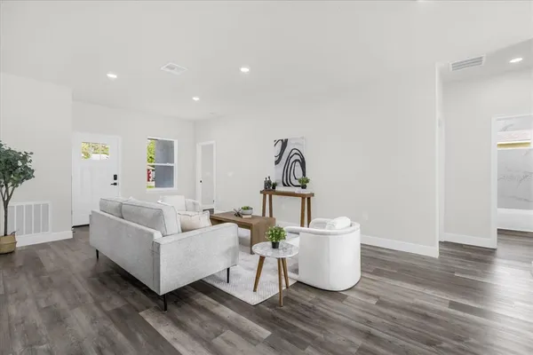 a living room with furniture and a wooden floor