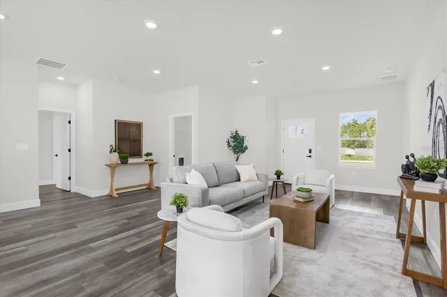 a living room with furniture a dining table and a potted plant