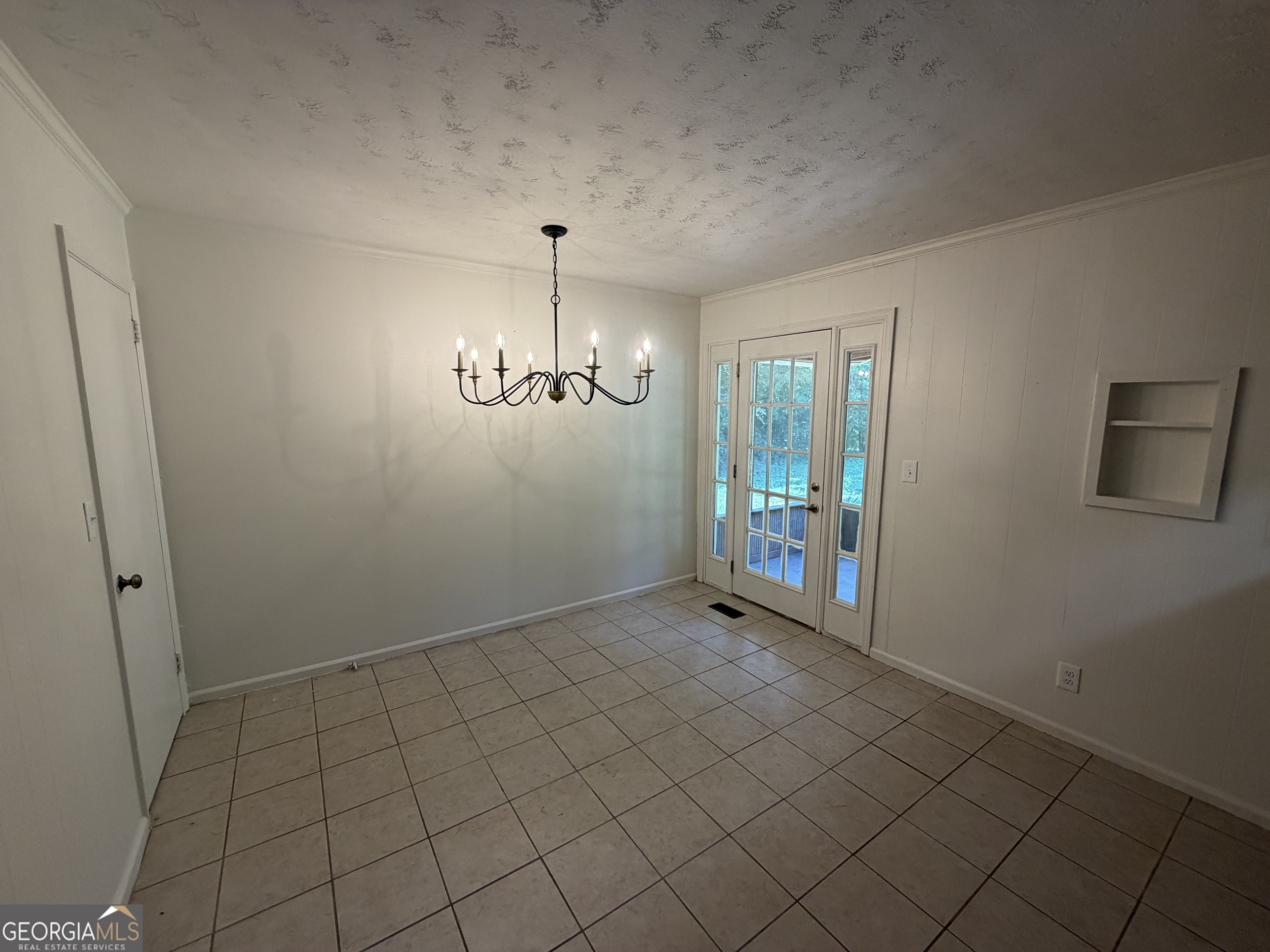 1005 North 1st Street Fort Valley, GA 31030 - Photo 11 of 28 an empty room with chandelier fan and windows