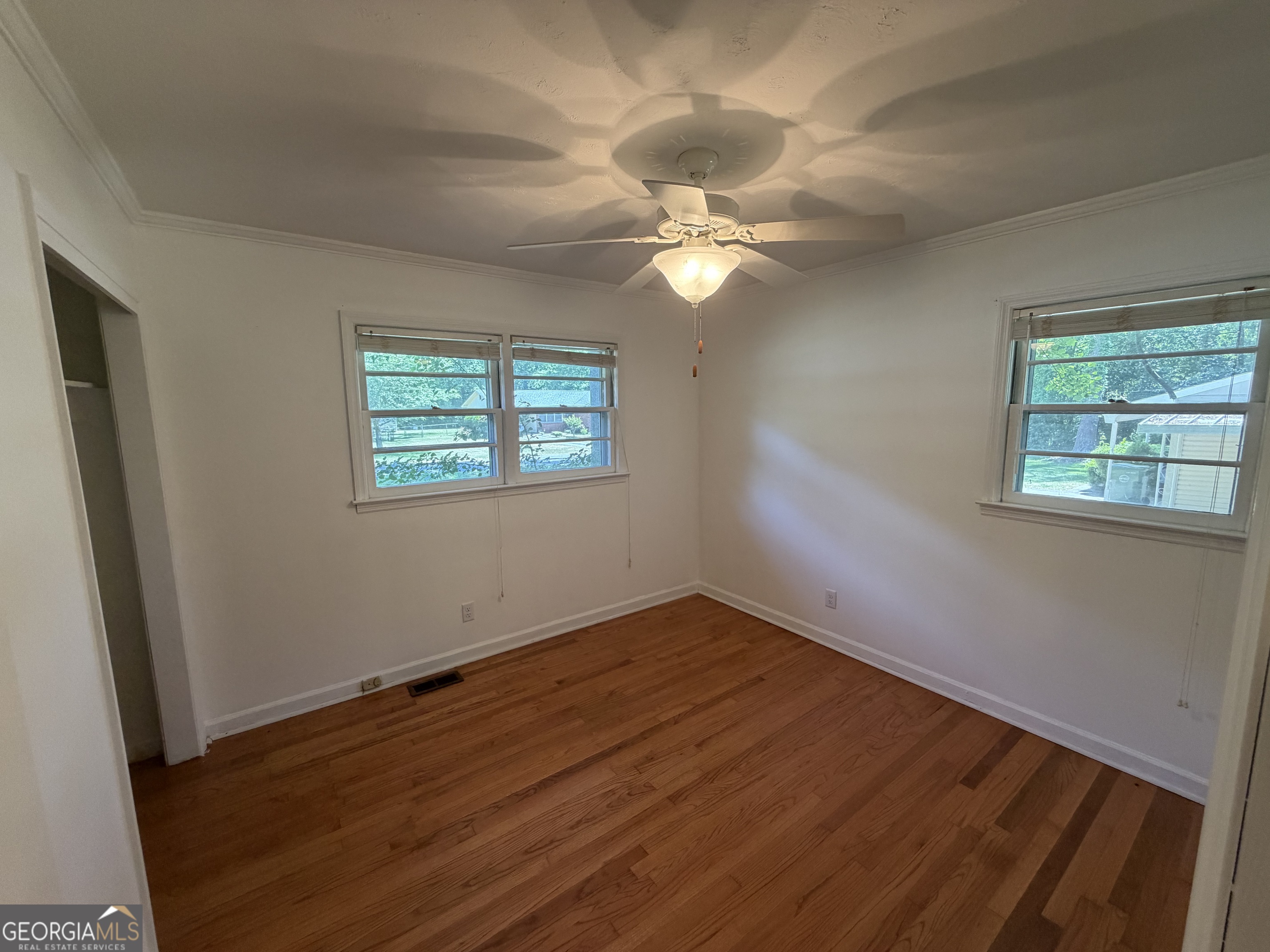 1005 North 1st Street Fort Valley, GA 31030 - Photo 16 of 28 a view of empty room with wooden floor and fan