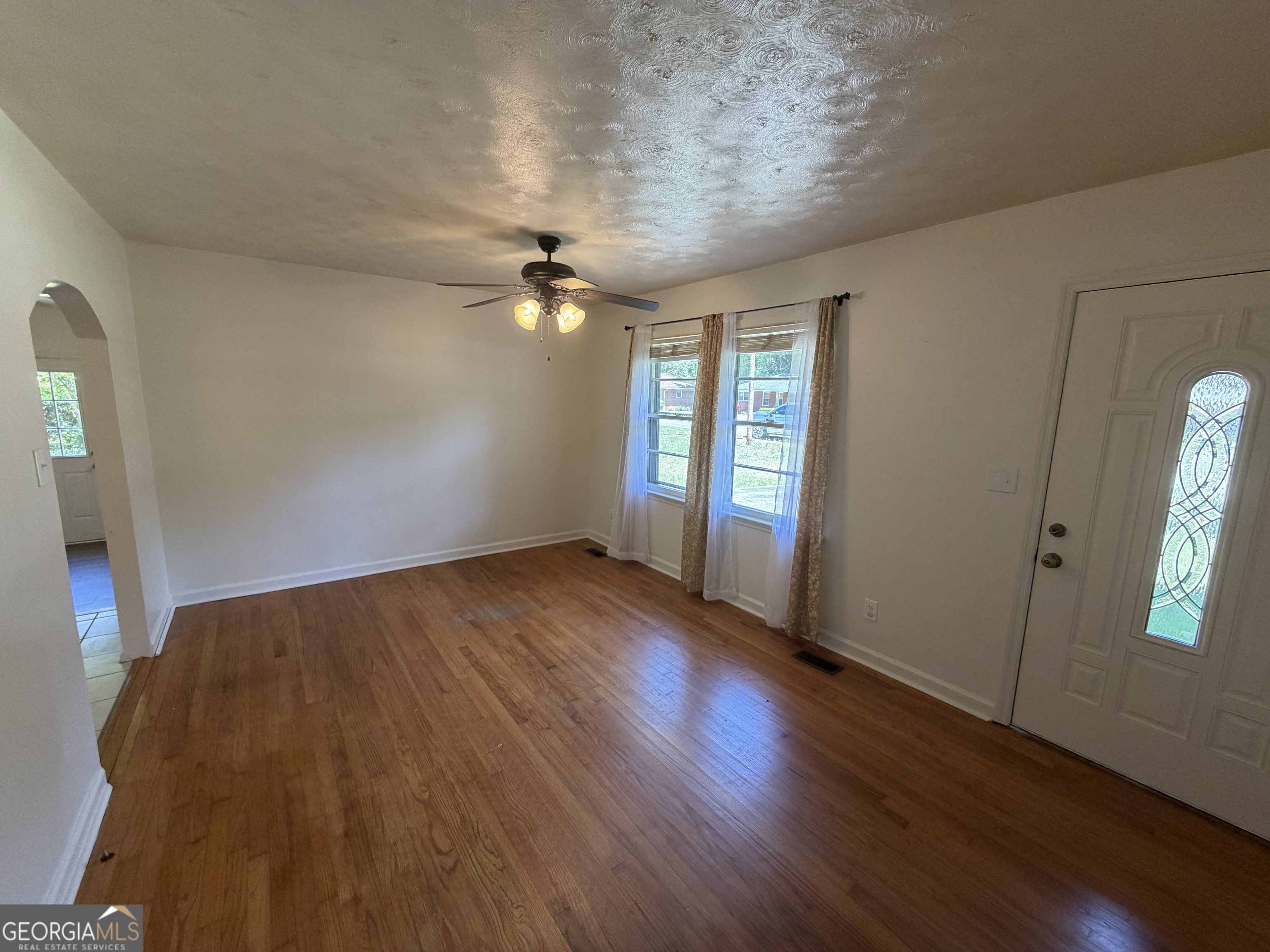 1005 North 1st Street Fort Valley, GA 31030 - Photo 5 of 28 an empty room with wooden floor and windows
