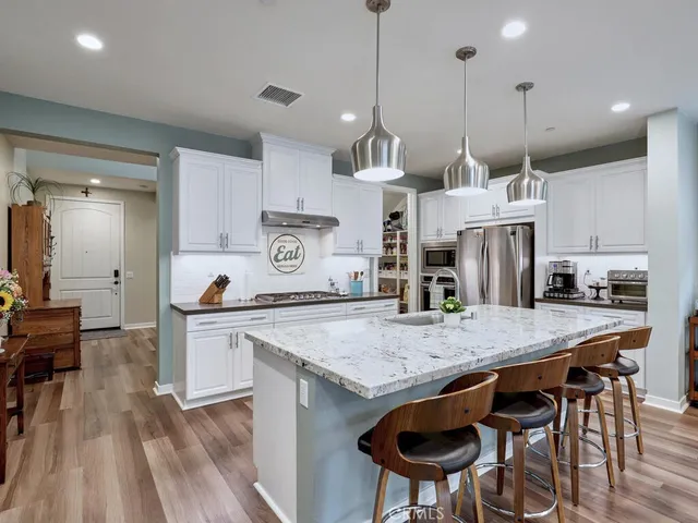 a kitchen with granite countertop a sink stainless steel appliances and cabinets