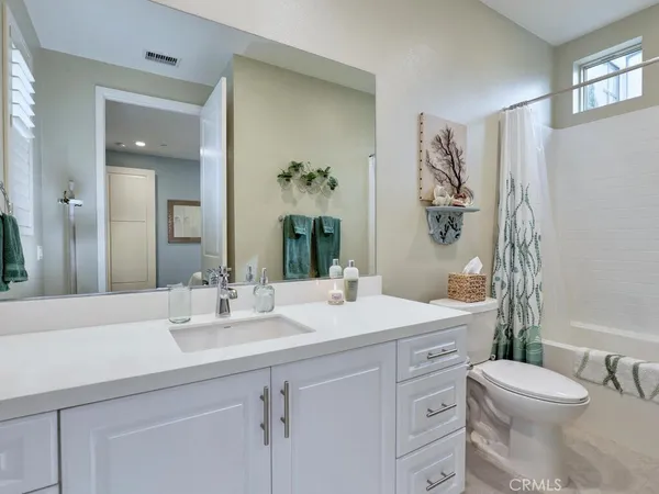 a kitchen with kitchen island a stove a sink a refrigerator and white cabinets with wooden floor
