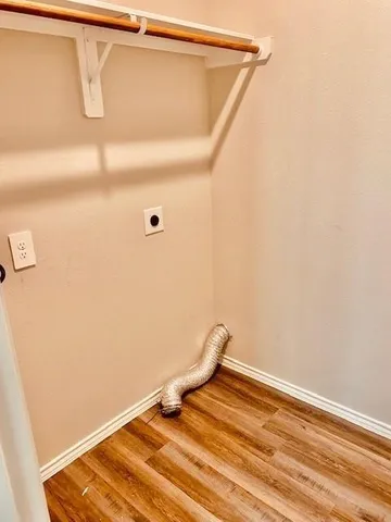 a view of a storage and utility room with wooden floor