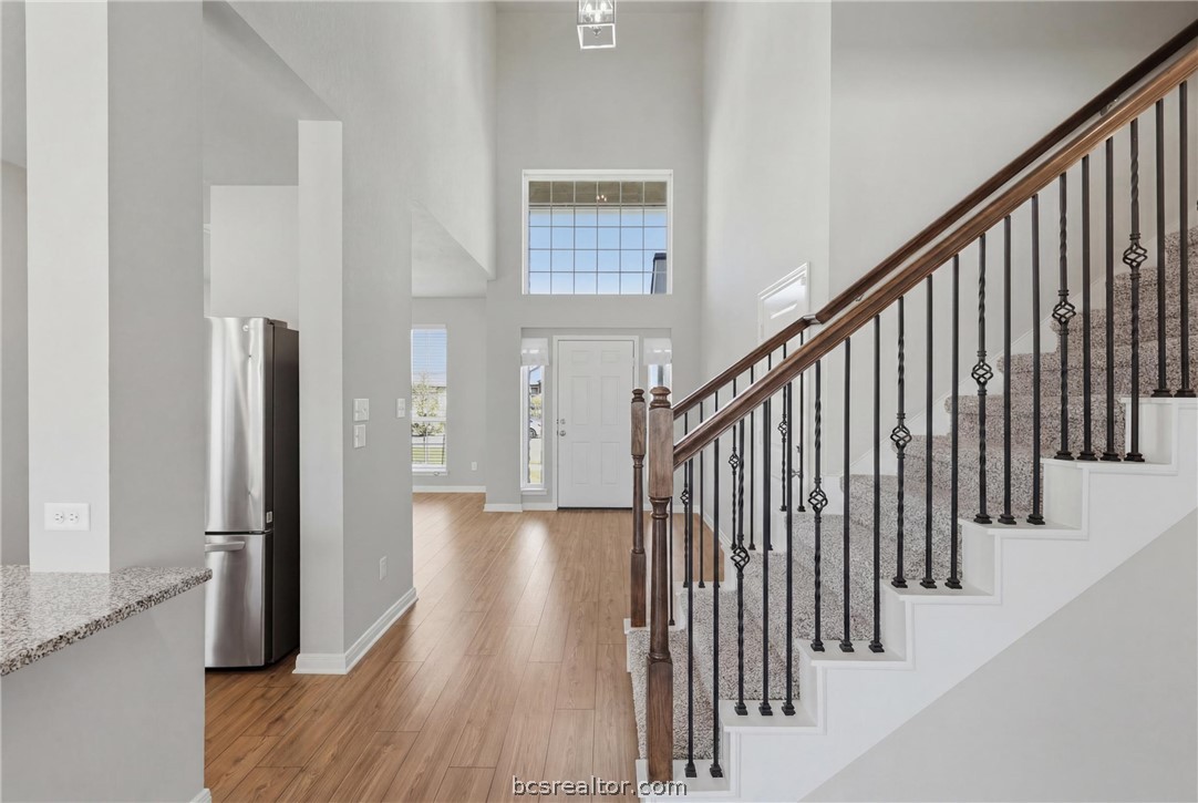 1922 Viva Road Bryan, TX 77807 - Photo 7 of 45 Welcoming entryway showcasing soaring ceilings, the home’s open-concept design, and stairway.