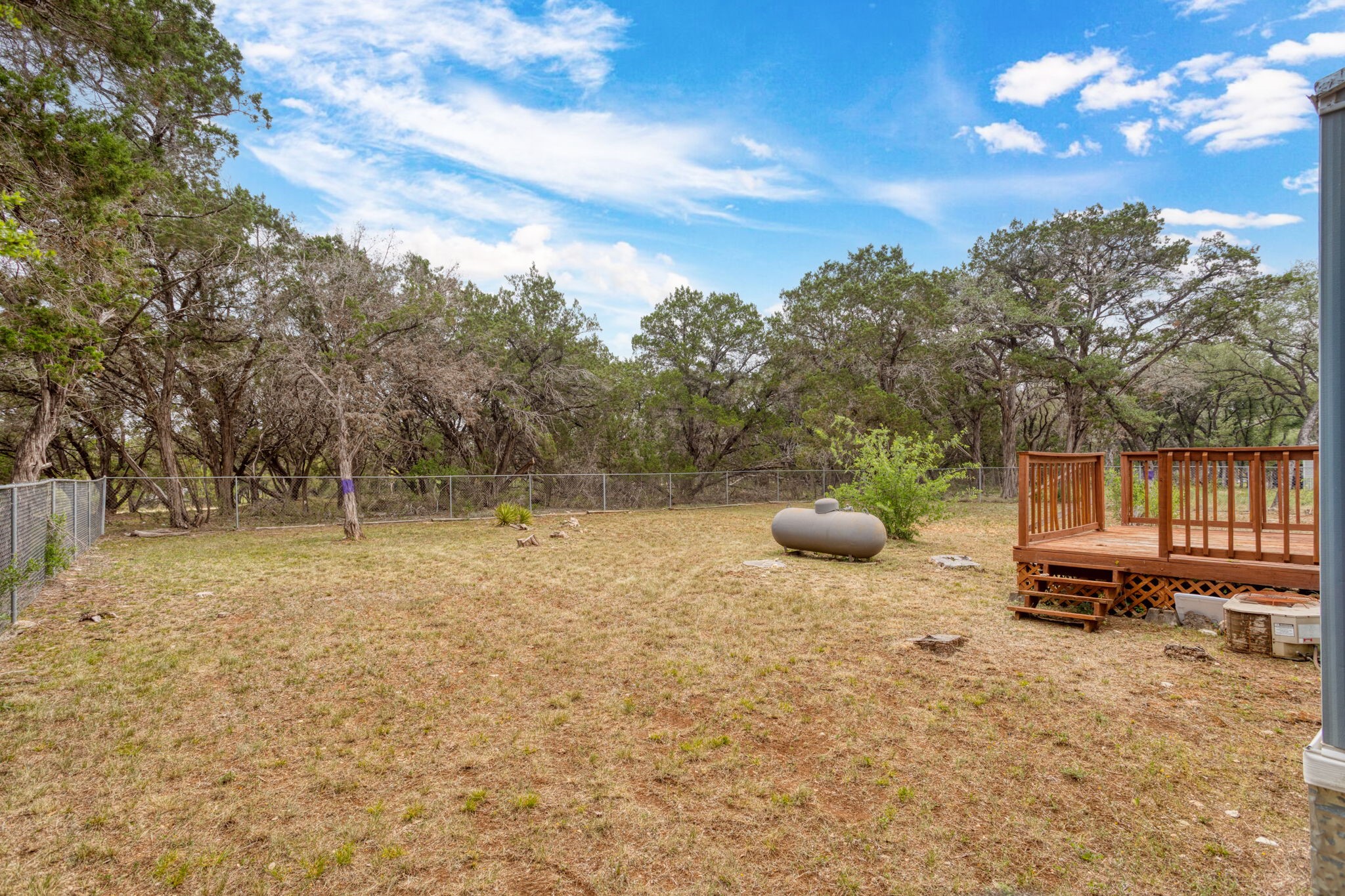 7075 Whartons Dock Road Bandera, TX 78003 - Photo 16 of 19 a view of a backyard with table and chairs a fire pit and trees