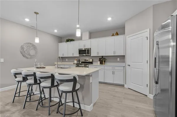 a kitchen with kitchen island granite countertop a sink cabinets and refrigerator