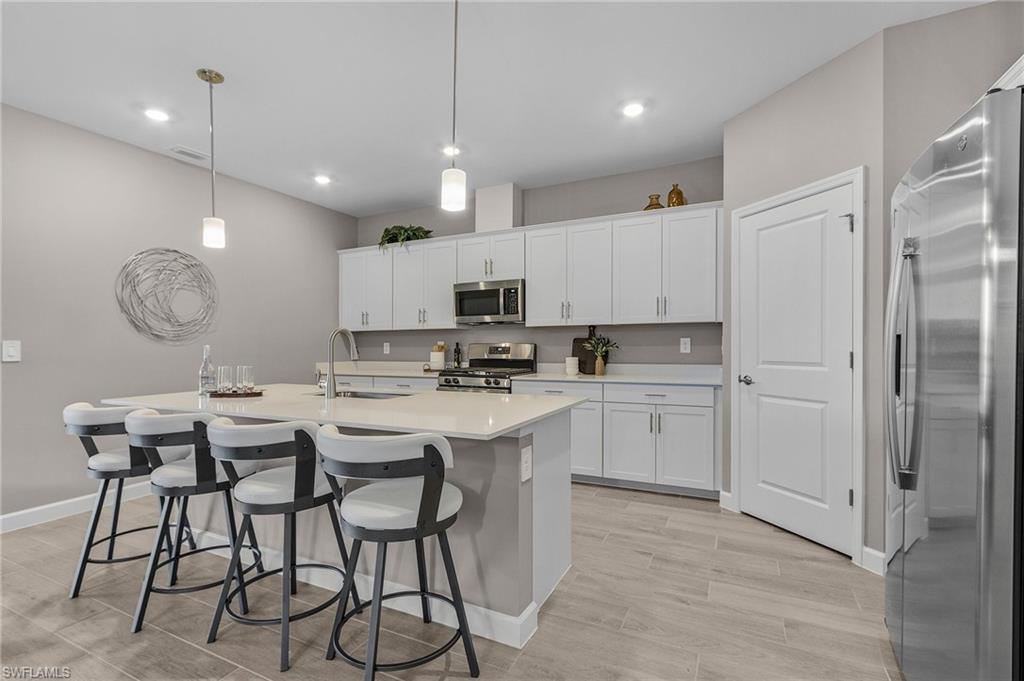 20716 Napa Loop Estero, FL 33928 - Photo 9 of 50 a kitchen with kitchen island granite countertop a sink cabinets and refrigerator