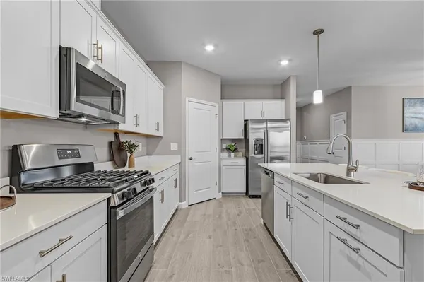 a kitchen with stainless steel appliances granite countertop a sink stove microwave and refrigerator