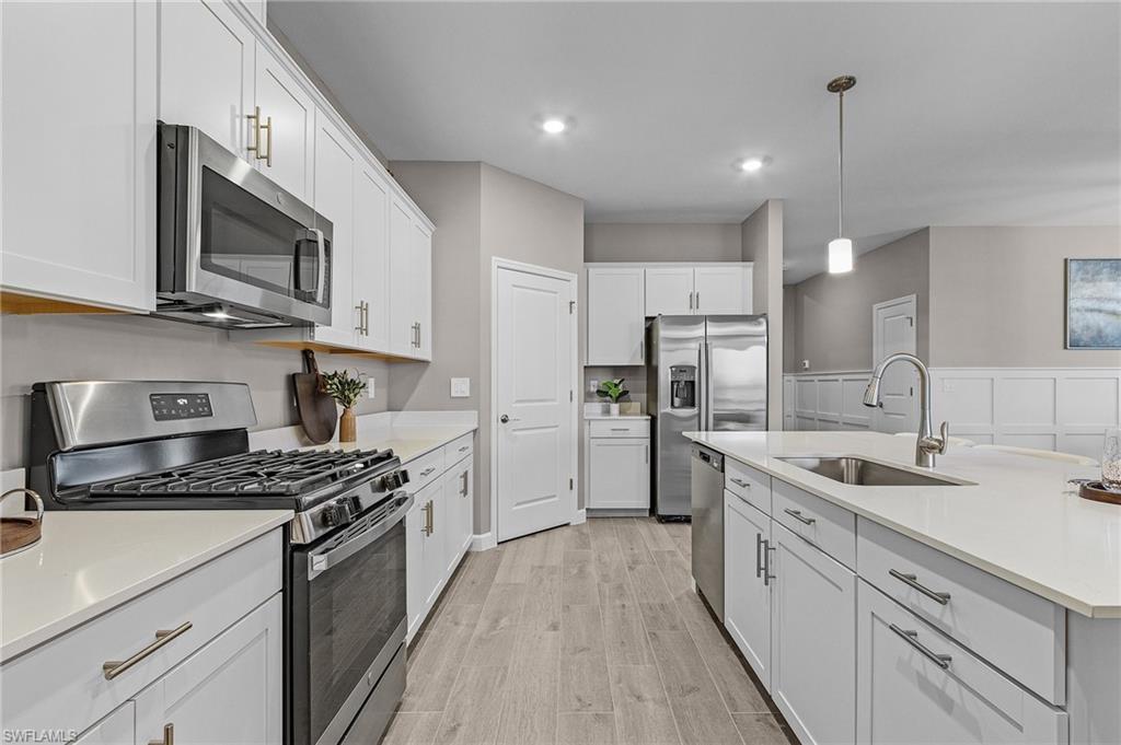 20716 Napa Loop Estero, FL 33928 - Photo 10 of 50 a kitchen with stainless steel appliances granite countertop a sink stove microwave and refrigerator