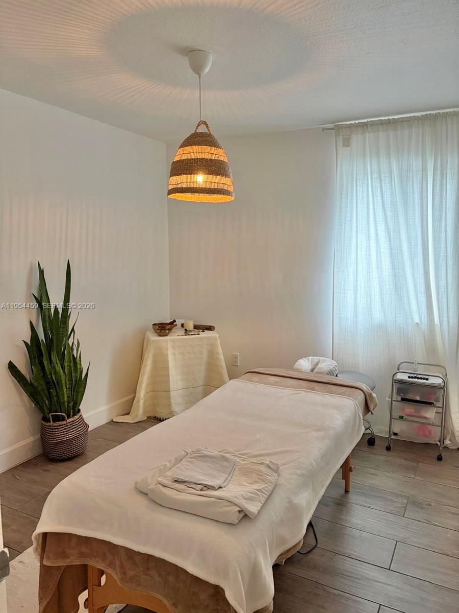 555 Northeast 70th Street Miami, FL 33138 - Photo 4 of 14 a bedroom with a bed and a chandelier